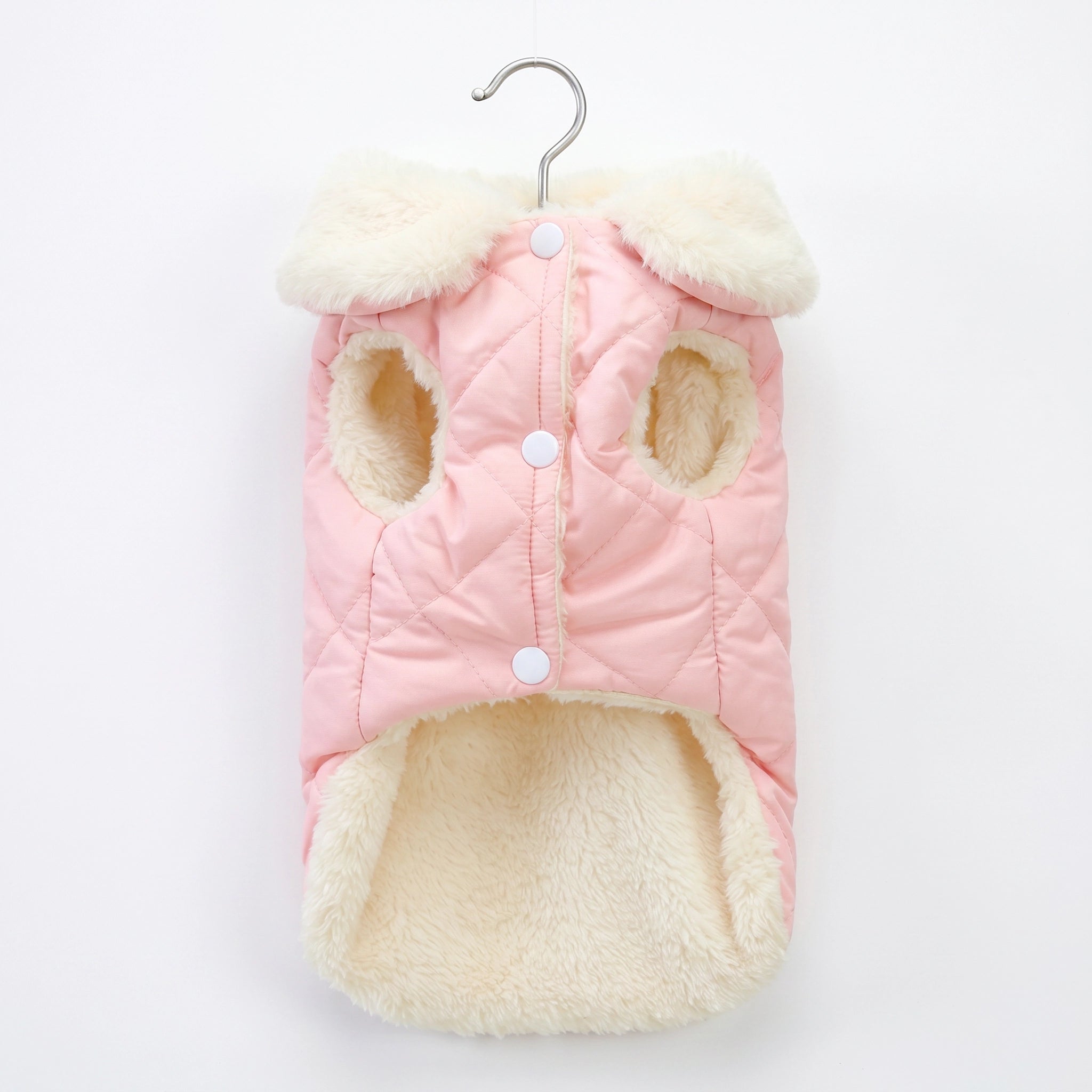Pink and cream quilted dog coat on a hanger against a white background
